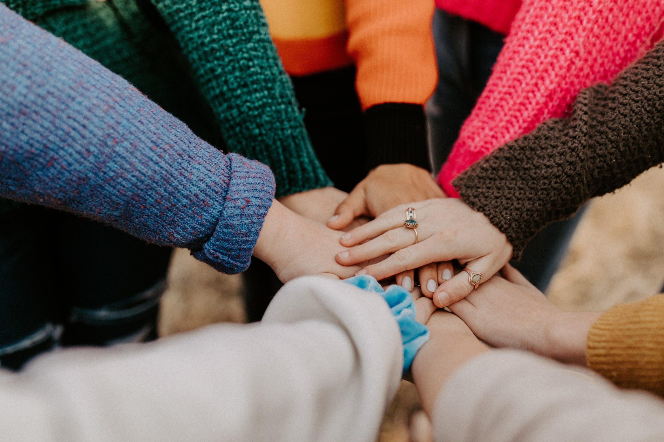 A group of people putting their hands together in a huddle